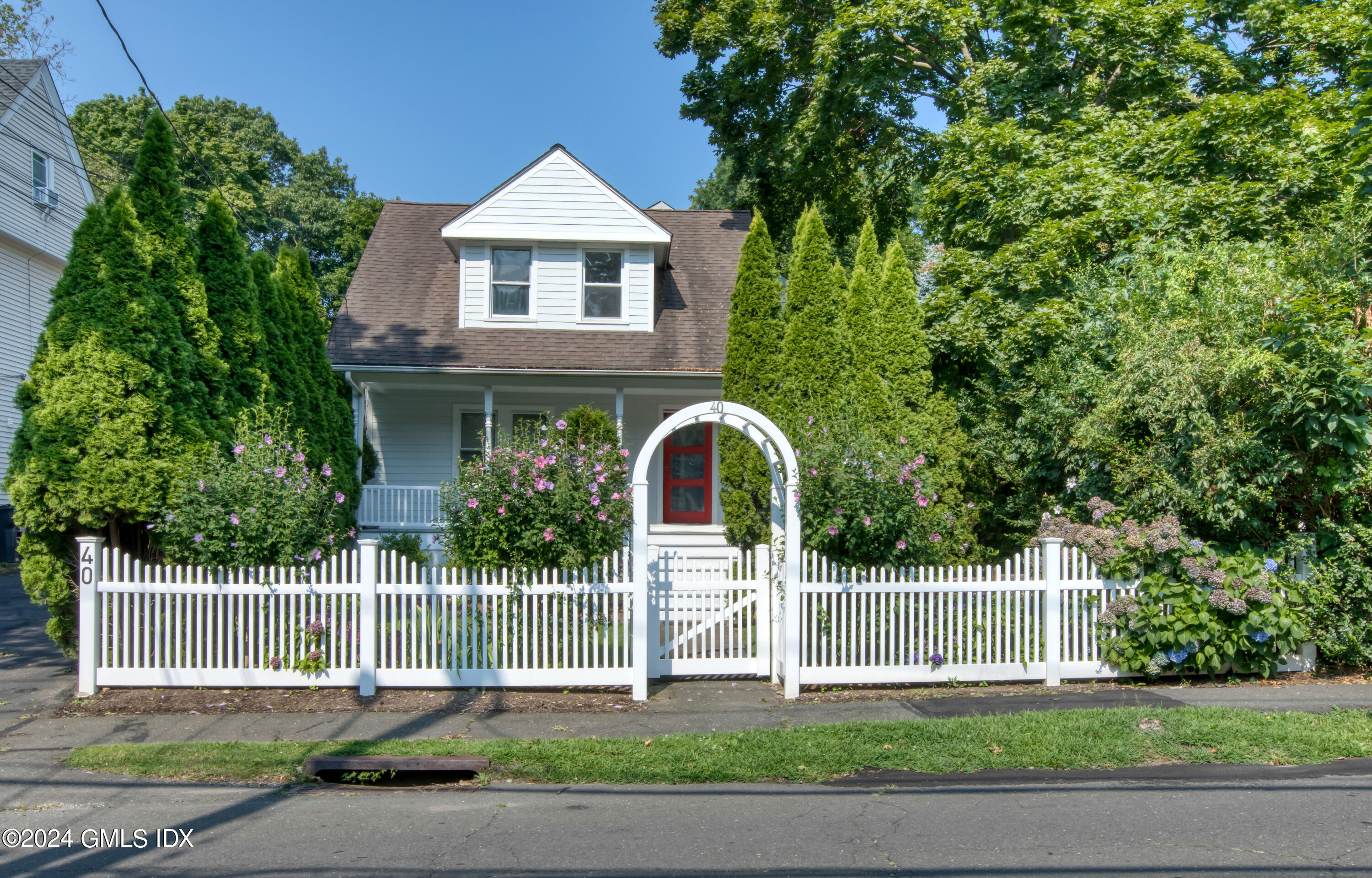40 Prospect Street, Unit 1 Greenwich, CT 06830 - Photo 1 of 18 a front view of a house with a garden and plants