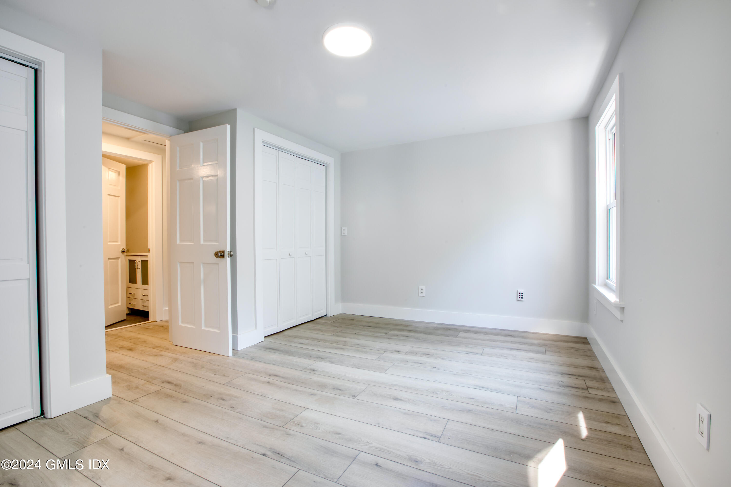 40 Prospect Street, Unit 1 Greenwich, CT 06830 - Photo 11 of 18 an empty room with wooden floor and windows