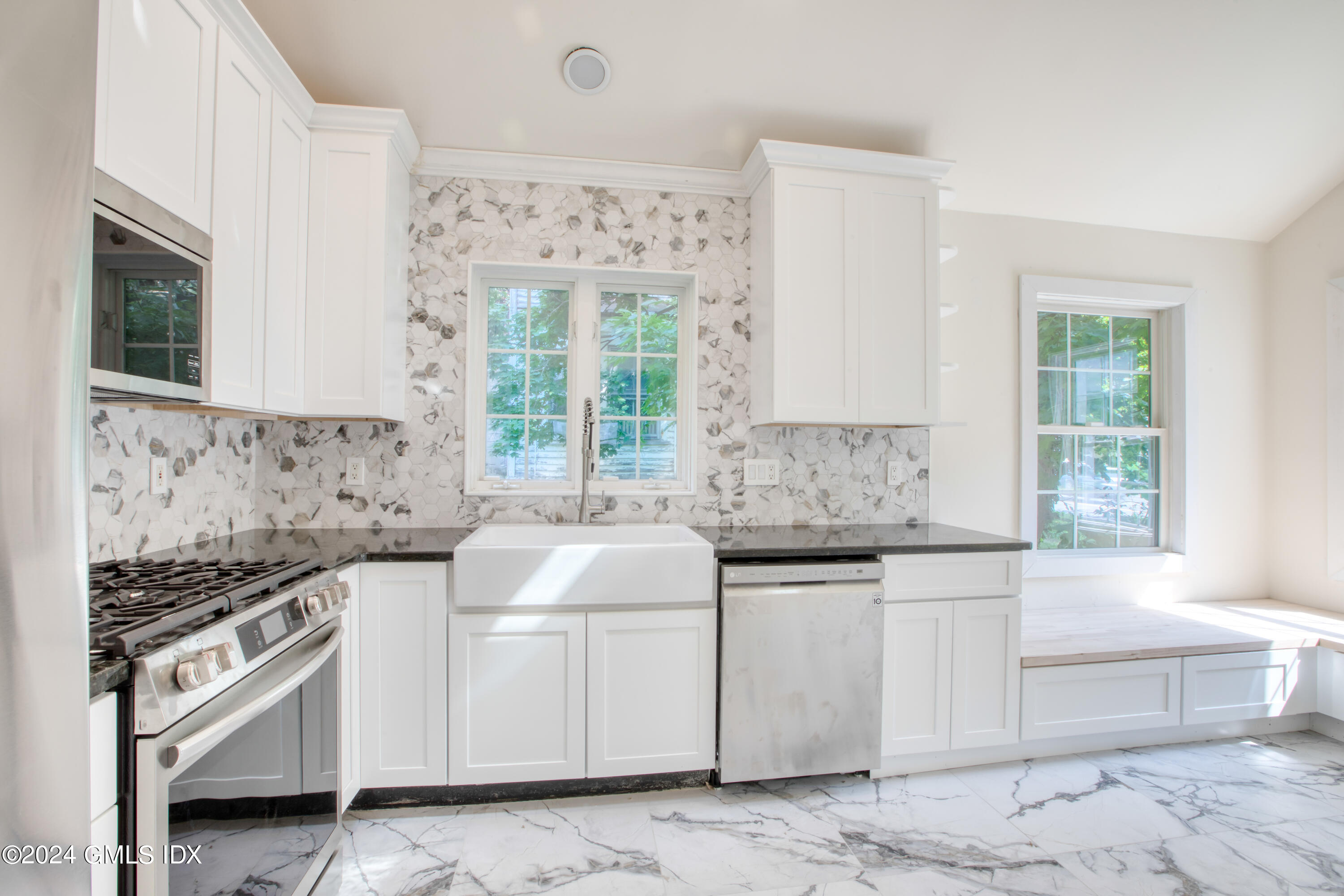 40 Prospect Street, Unit 1 Greenwich, CT 06830 - Photo 3 of 18 a kitchen with granite countertop a sink a stove a microwave and cabinets