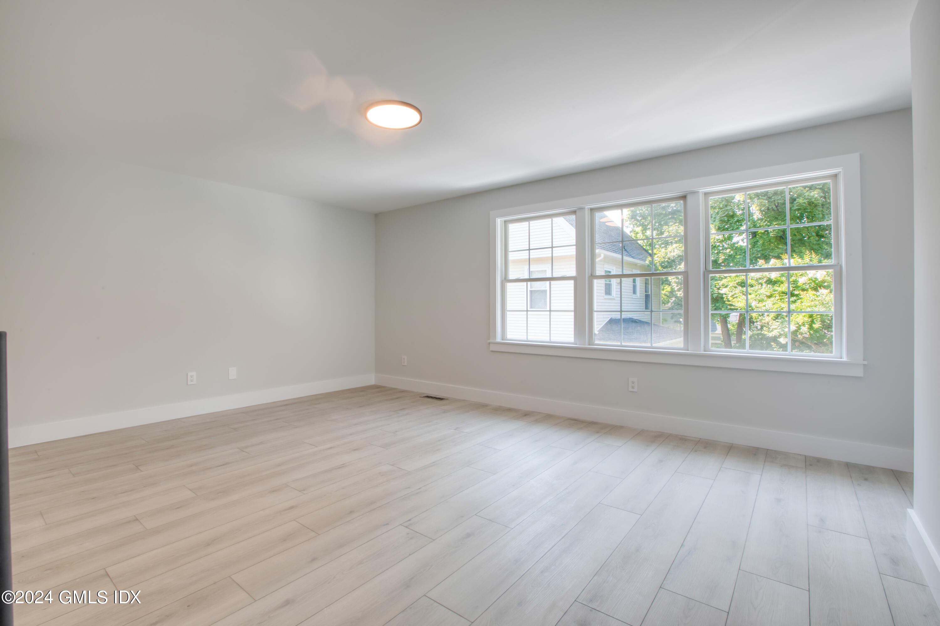 40 Prospect Street, Unit 1 Greenwich, CT 06830 - Photo 10 of 18 an empty room with wooden floor and windows