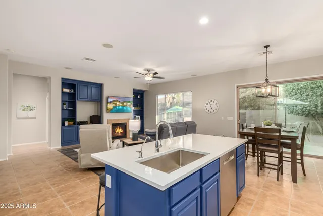a kitchen with a stove a sink a dining table and chairs with wooden floor