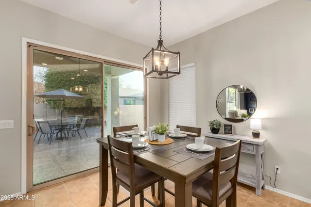 a dining room with wooden floor a chandelier a wooden table and chairs
