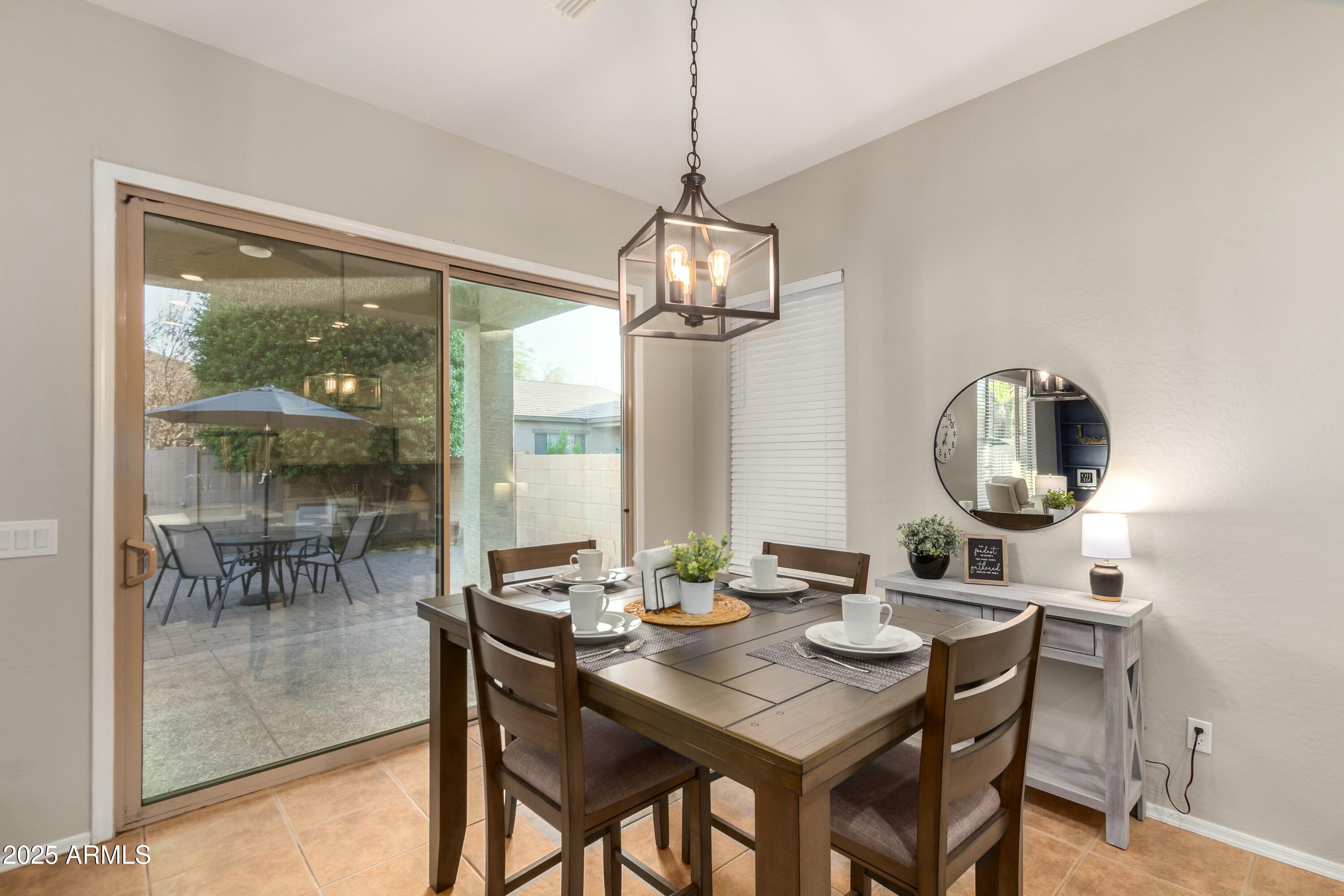 3419 West Zuni Brave Trail Phoenix, AZ 85086 - Photo 12 of 51 a dining room with wooden floor a chandelier a wooden table and chairs