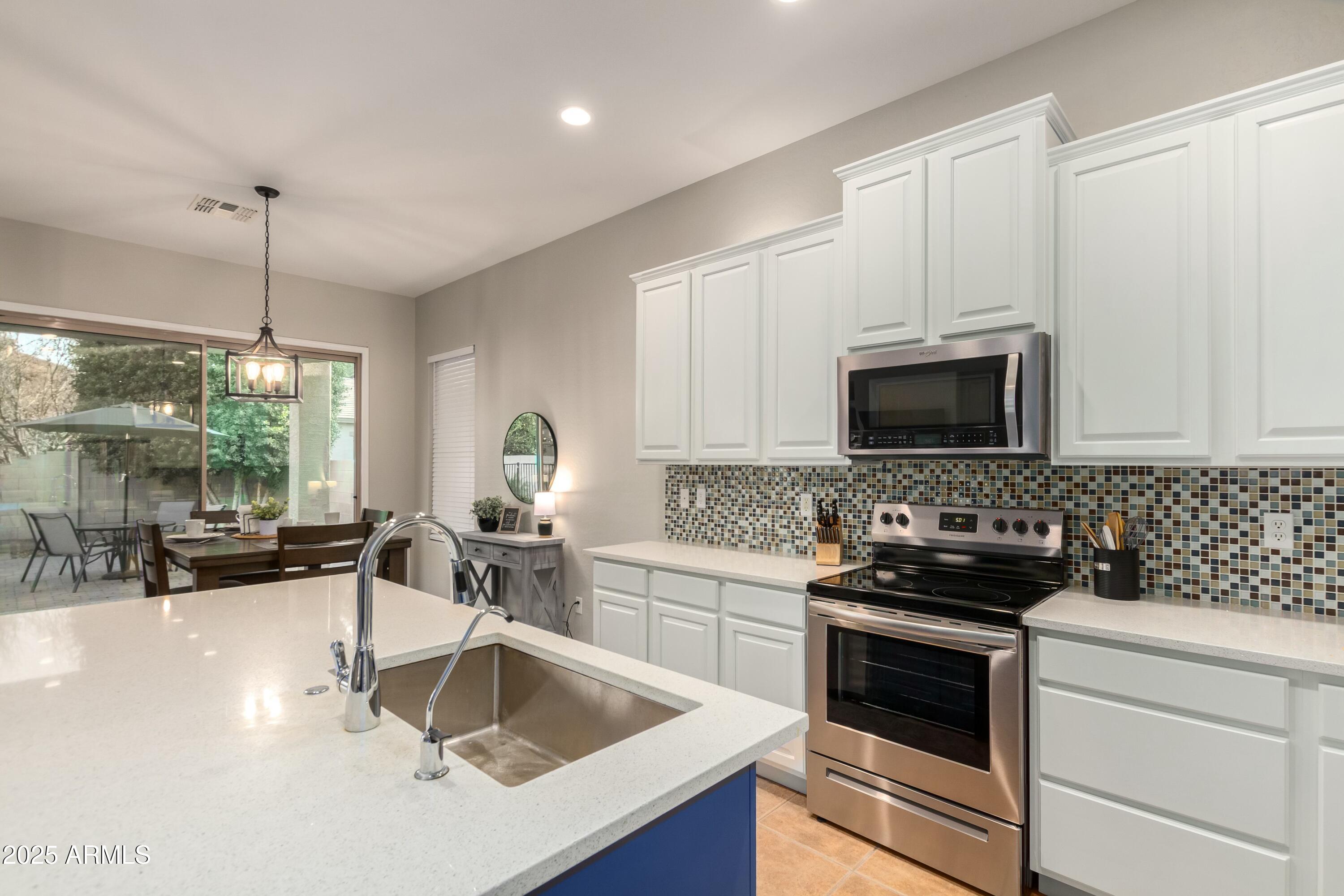 3419 West Zuni Brave Trail Phoenix, AZ 85086 - Photo 17 of 51 a kitchen with granite countertop a sink and a stove