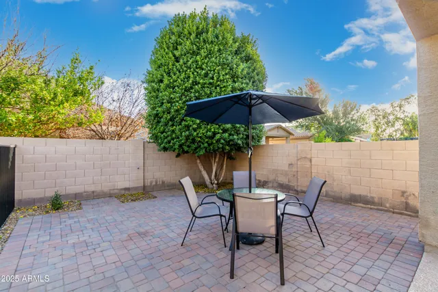 a patio with wooden floor a yard a table and chairs
