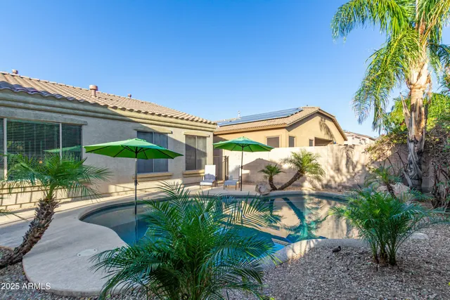 a patio with a table and chairs under an umbrella