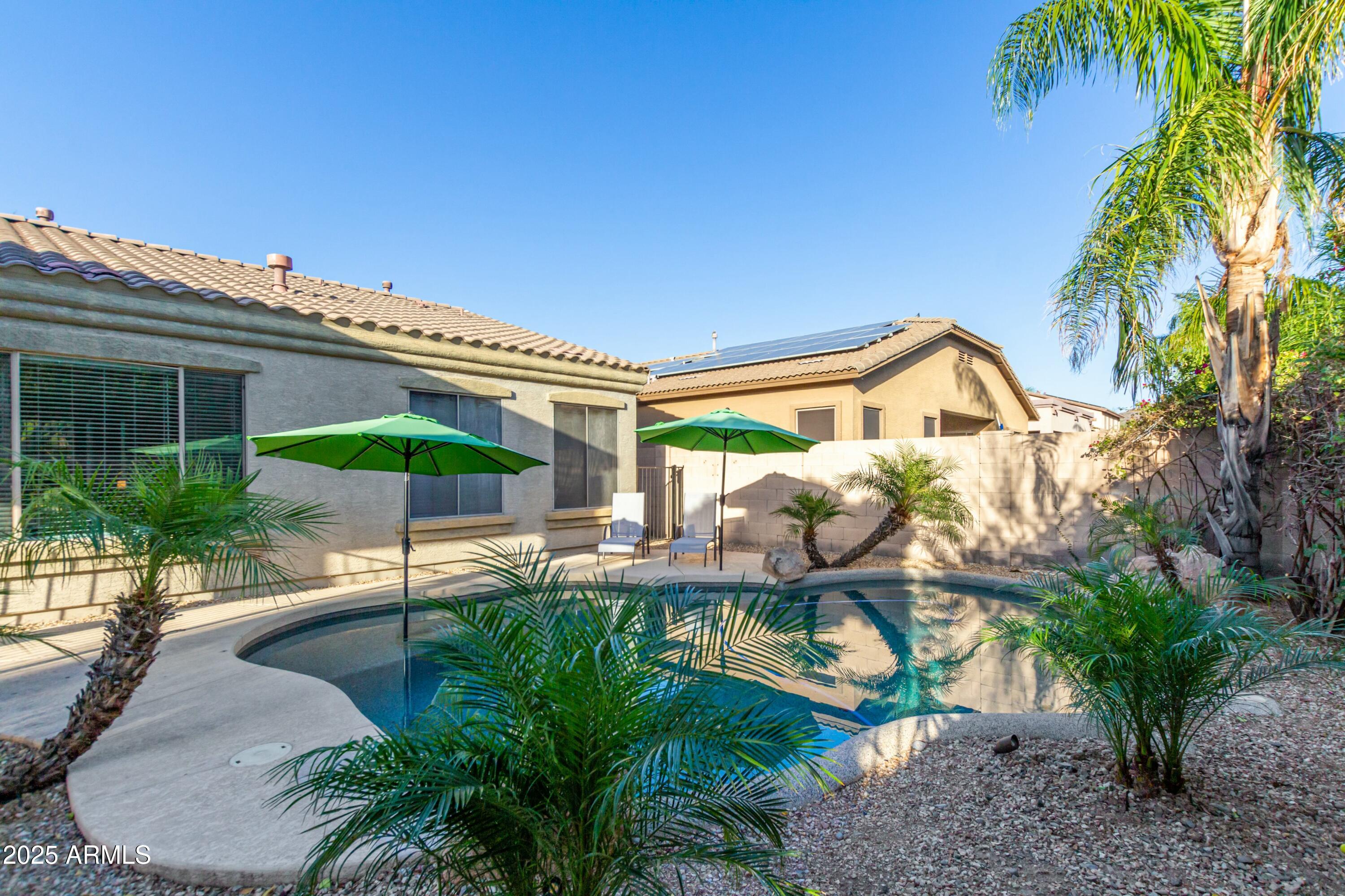 3419 West Zuni Brave Trail Phoenix, AZ 85086 - Photo 34 of 51 a backyard of a house with table and chairs under an umbrella
