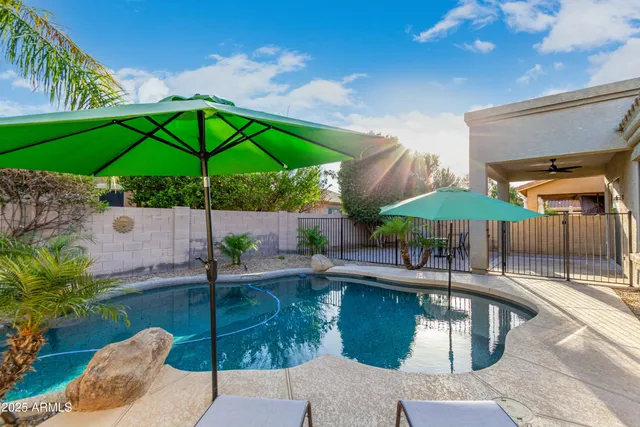 a patio with a table and chairs under an umbrella