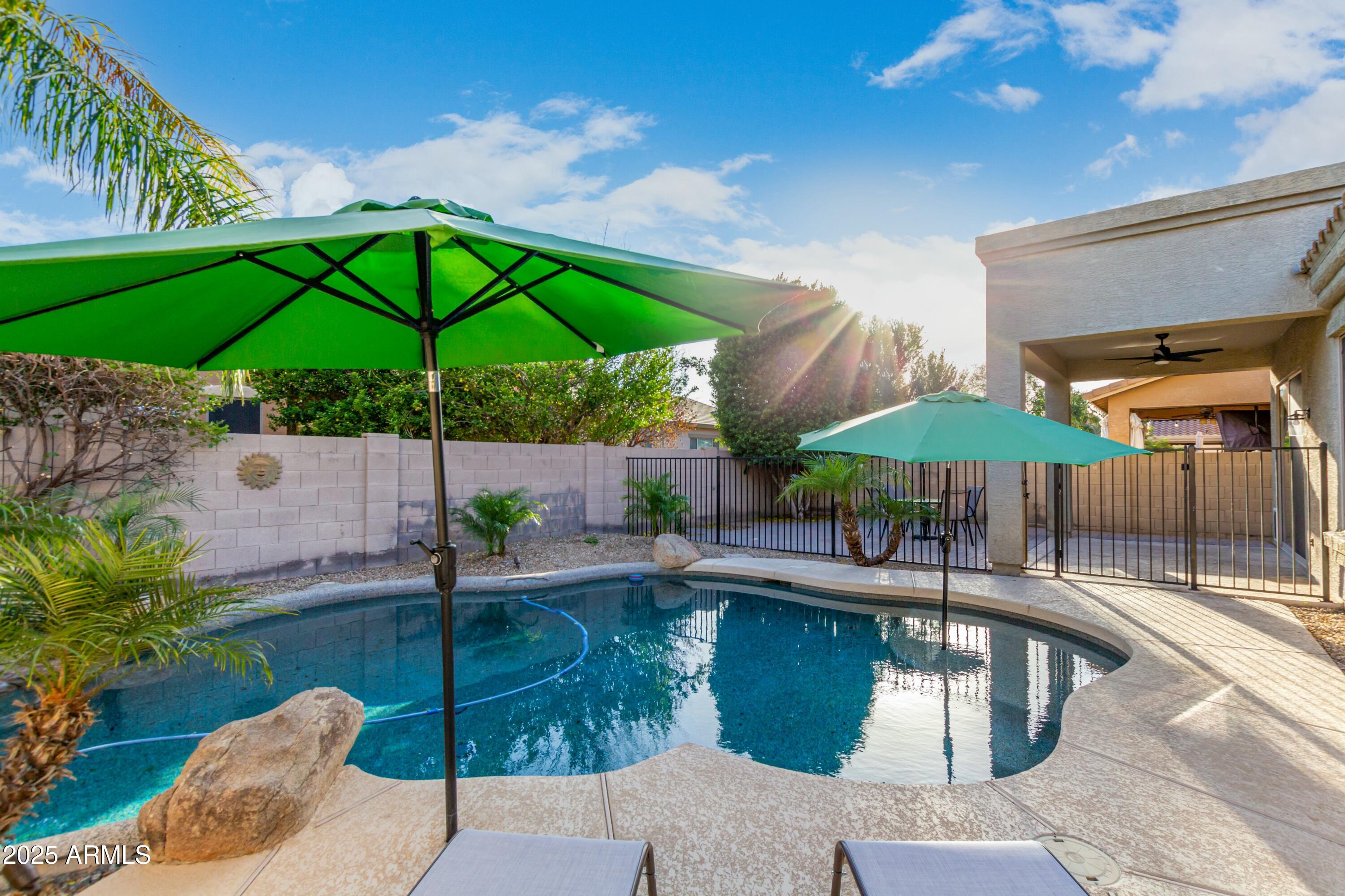 3419 West Zuni Brave Trail Phoenix, AZ 85086 - Photo 35 of 51 a patio with a table and chairs under an umbrella