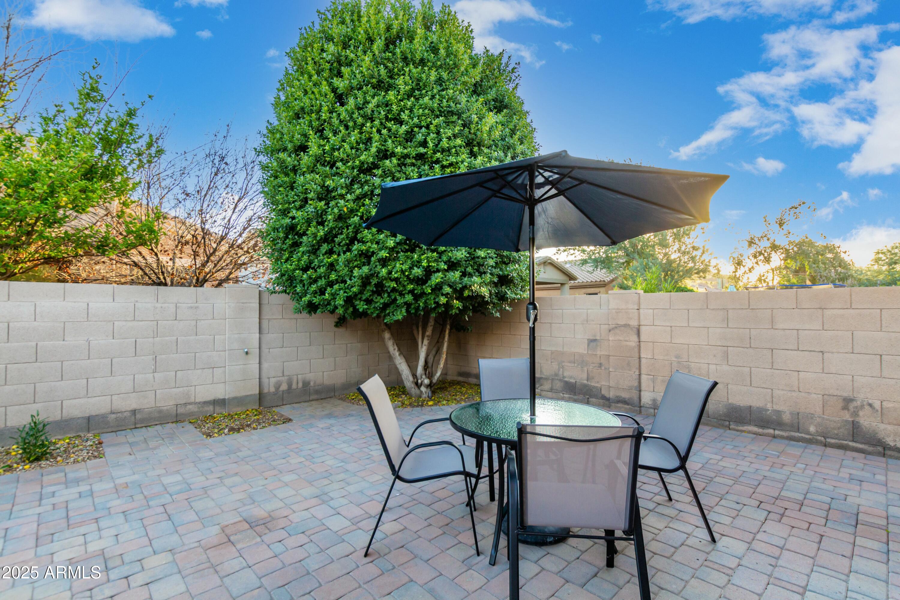 3419 West Zuni Brave Trail Phoenix, AZ 85086 - Photo 38 of 51 a patio table and chairs under an umbrella