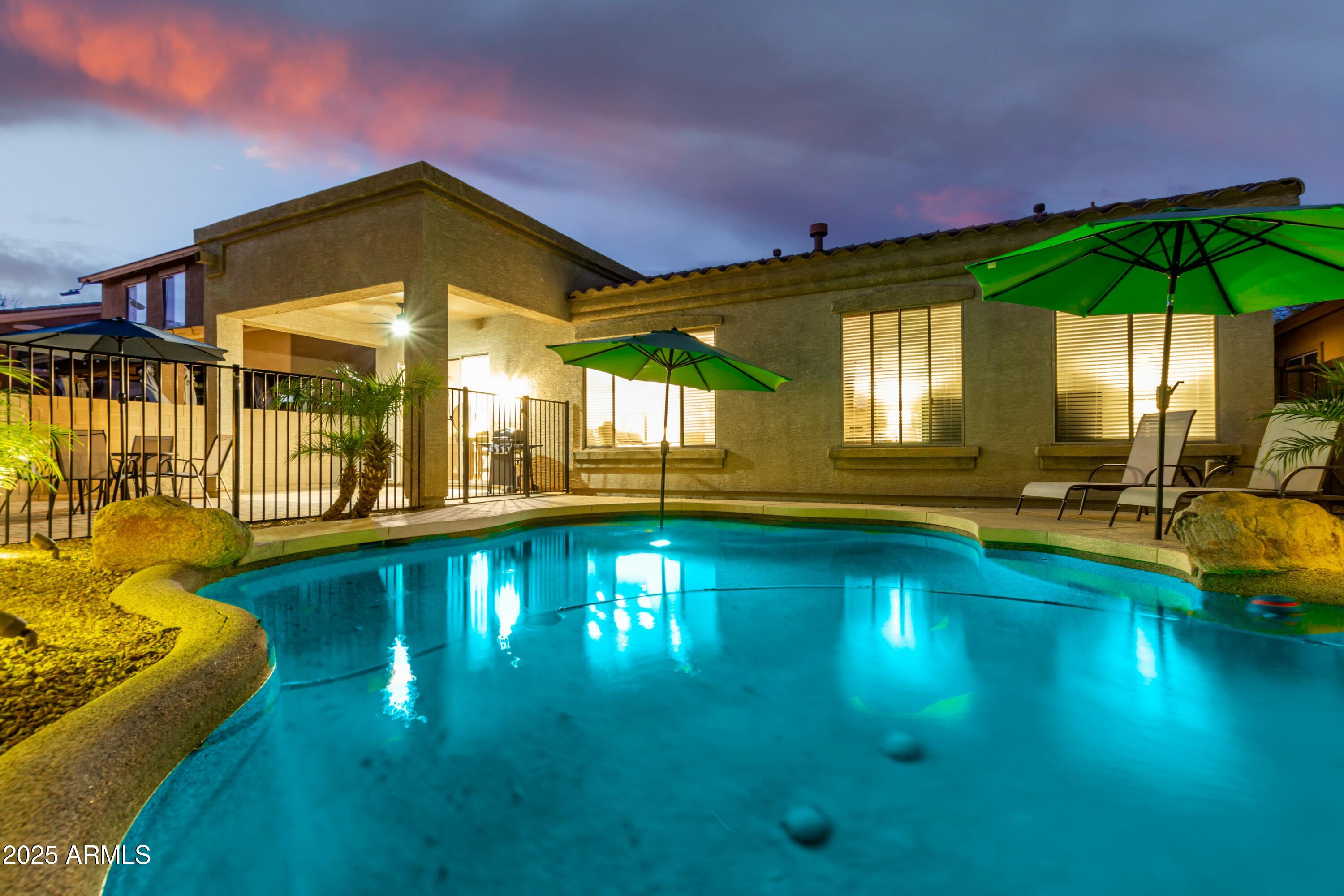 3419 West Zuni Brave Trail Phoenix, AZ 85086 - Photo 47 of 51 a view of swimming pool with lawn chairs under an umbrella