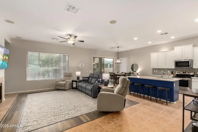a living room with furniture kitchen view and a large window