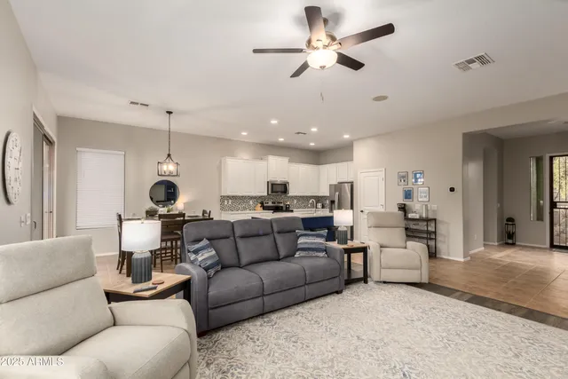 a living room with furniture kitchen view and a chandelier