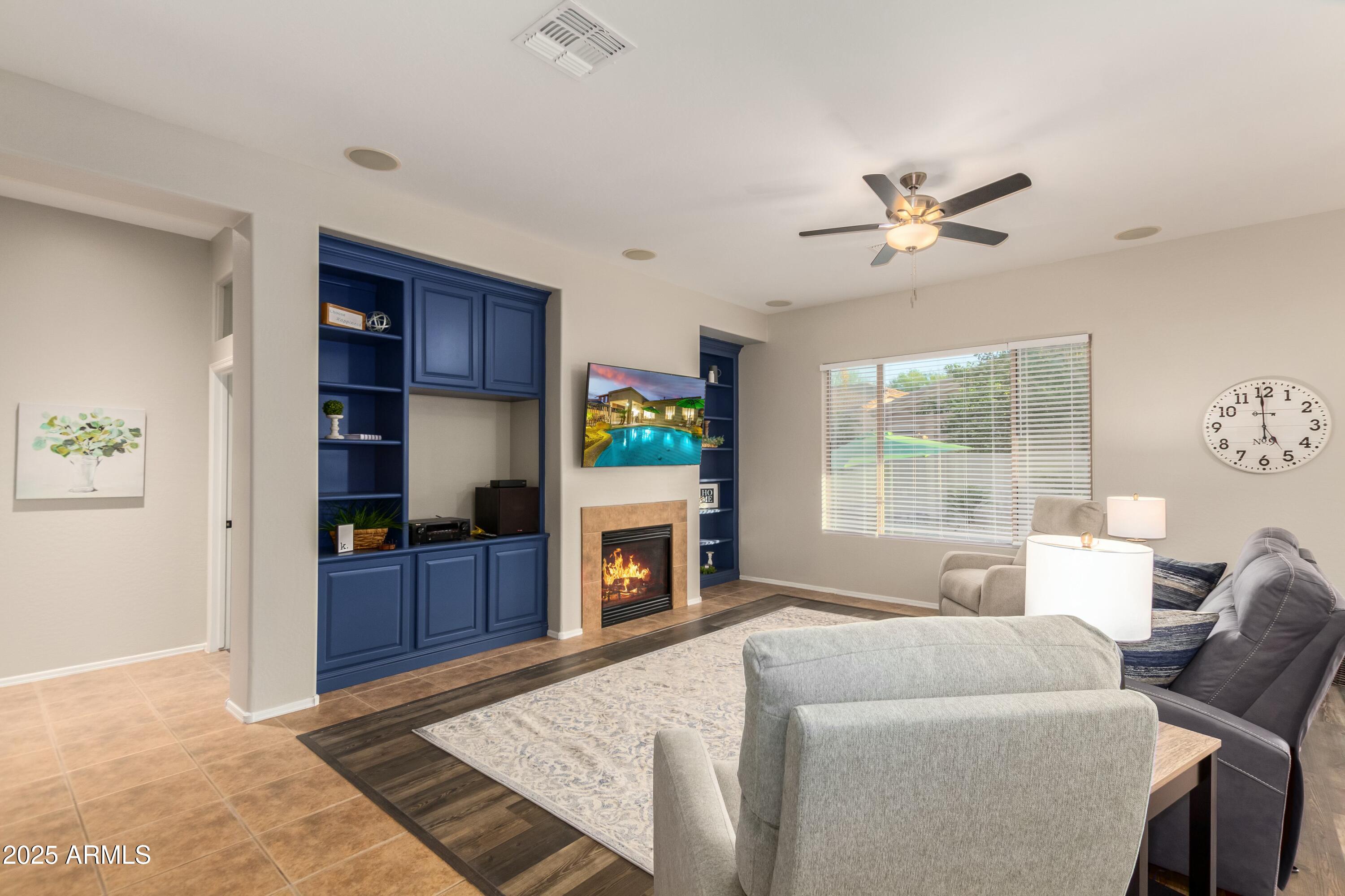 3419 West Zuni Brave Trail Phoenix, AZ 85086 - Photo 9 of 51 a living room with furniture a fireplace and a flat screen tv