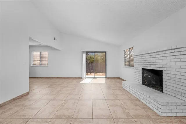 a view of an empty room with window and fire place