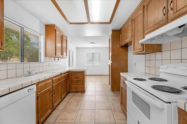 a kitchen with stainless steel appliances granite countertop a stove a sink and a refrigerator