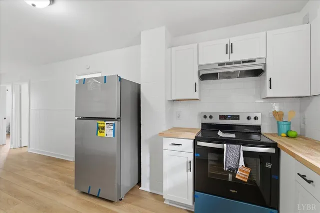 a kitchen with stainless steel appliances a stove a refrigerator and cabinets