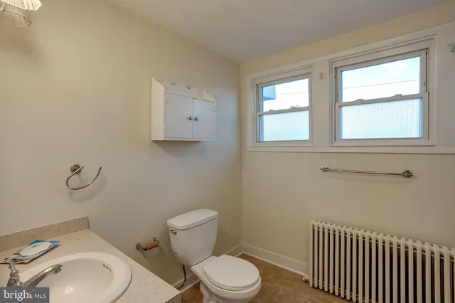 a white toilet sitting next to a bathroom sink