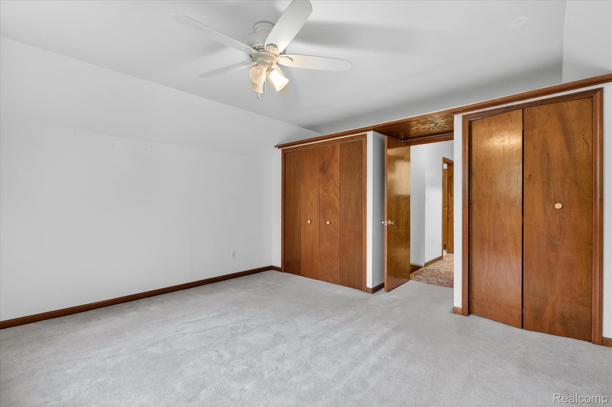 41303 Harris Road Belleville, MI 48111 - Photo 33 of 49 Unfurnished bedroom with vaulted ceiling, multiple closets, light colored carpet, and ceiling fan