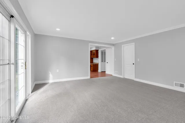 a view of an empty room with wooden floor and entryway