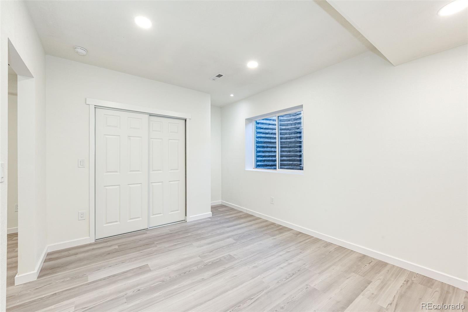1951 Ruffino Drive Colorado Springs, CO 80921 - Photo 19 of 39 an empty room with wooden floor and windows