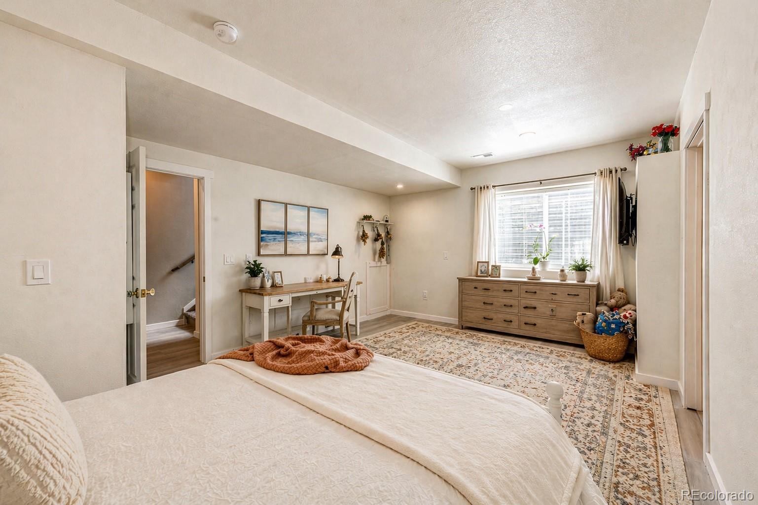 1951 Ruffino Drive Colorado Springs, CO 80921 - Photo 27 of 39 a bedroom with a bed a large mirror and a window