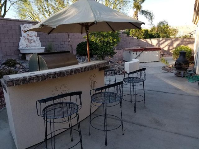 a patio with wooden table and chairs