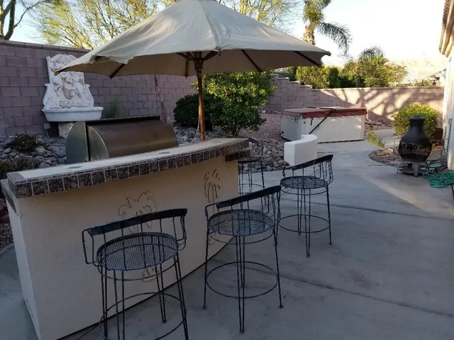 a patio with wooden table and chairs