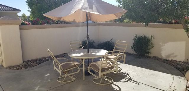 a living room with patio furniture and a floor to ceiling window