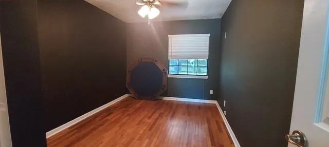 a view of a room with wooden floor and a window