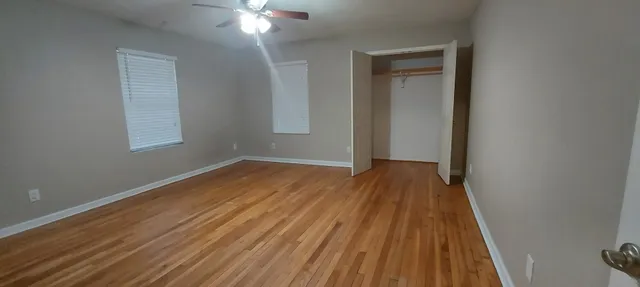 a view of a room with wooden floor and a ceiling fan