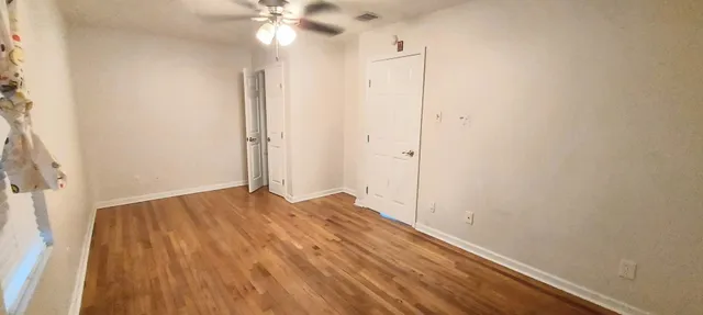 a view of empty room with wooden floor