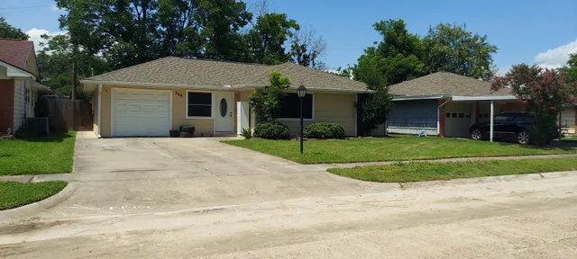 a front view of a house with a garden and yard