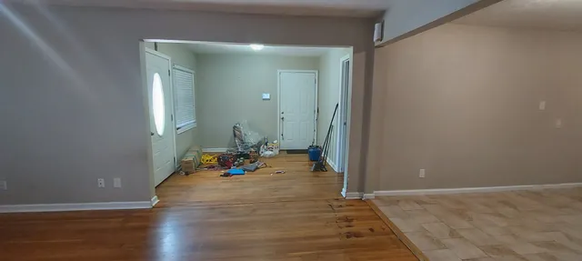 a view of a livingroom with wooden floor and a sink