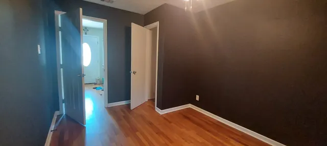 a room with a wooden floor and a window