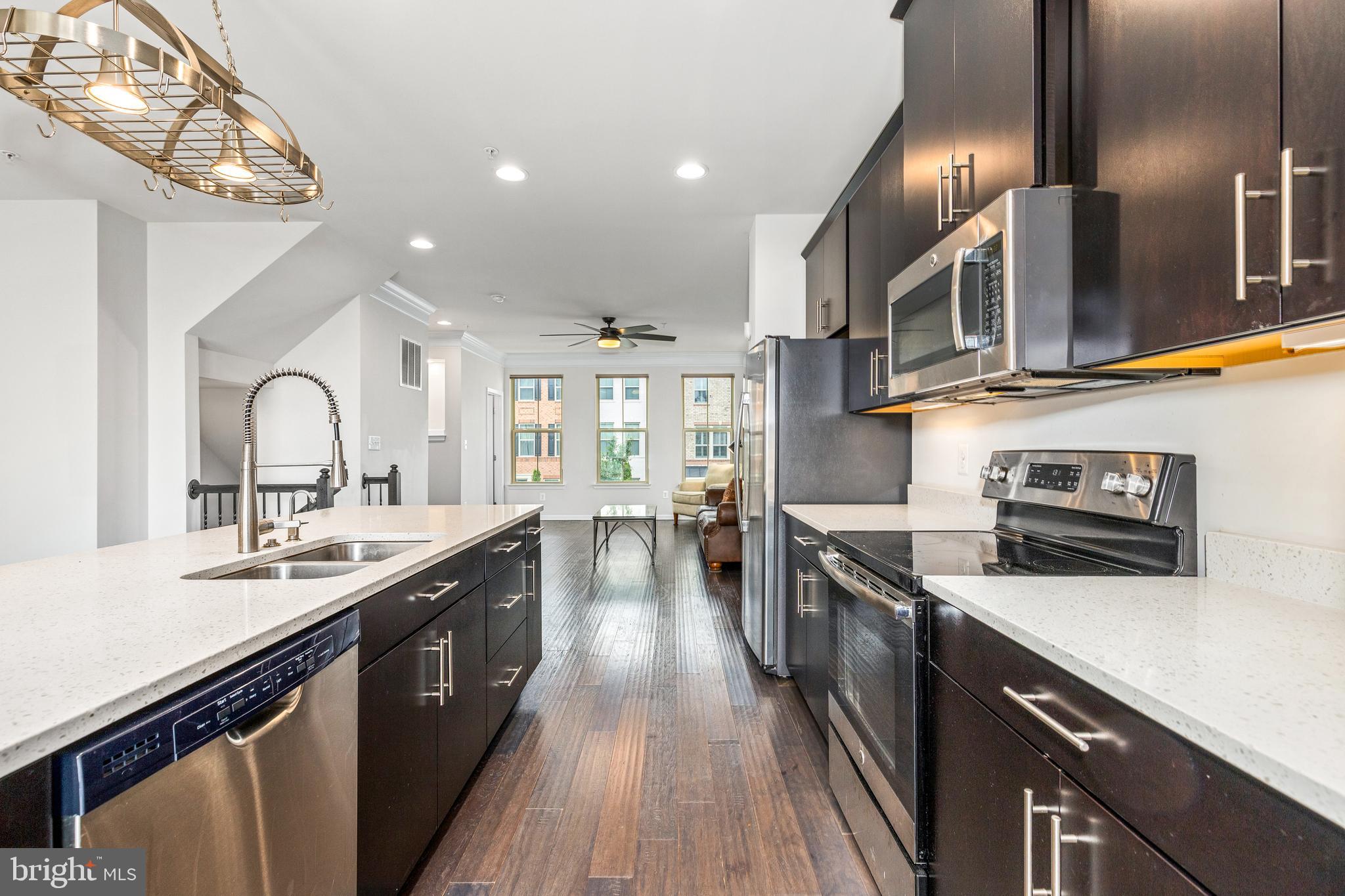 3629 Jamison Street Northeast Washington, DC 20018 - Photo 12 of 30 a kitchen with stainless steel appliances granite countertop a sink a stove top oven a counter space and cabinets