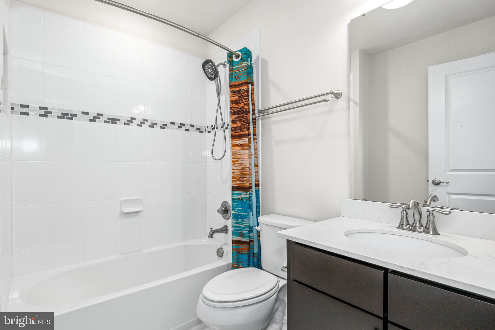 3629 Jamison Street Northeast Washington, DC 20018 - Photo 23 of 30 a bathroom with a sink a toilet a mirror a bathtub and shower