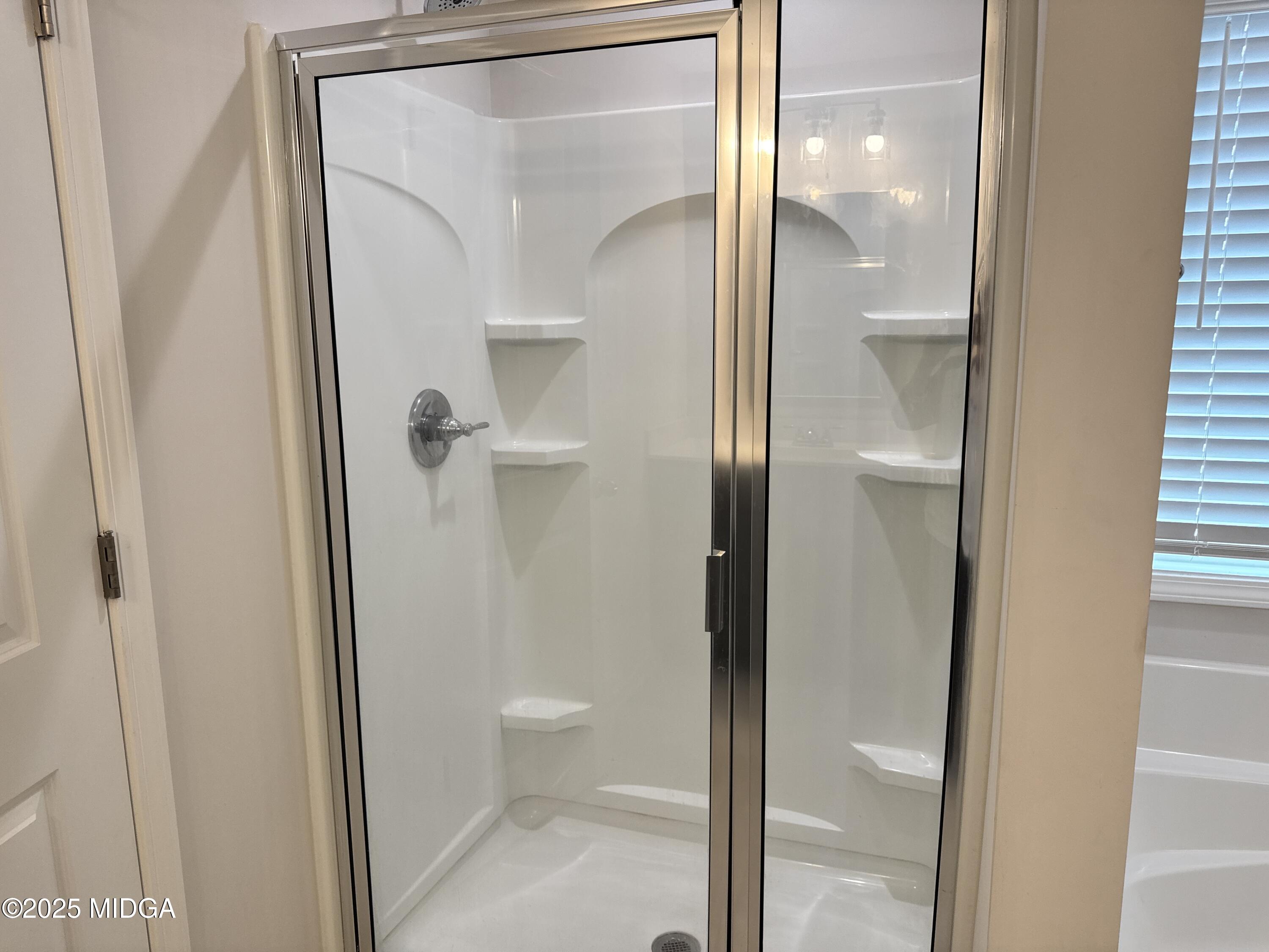 1082 Victorian Boulevard Forsyth, GA 31029 - Photo 16 of 23 a bathroom that has a glass shower door