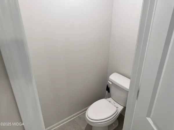 a white toilet sitting next to a shower