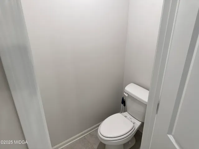 a white toilet sitting next to a shower