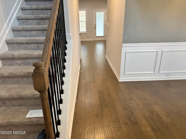 an entryway with a floor to ceiling window and stairs
