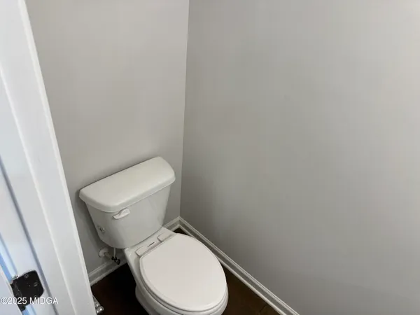a white toilet sitting next to a white wall
