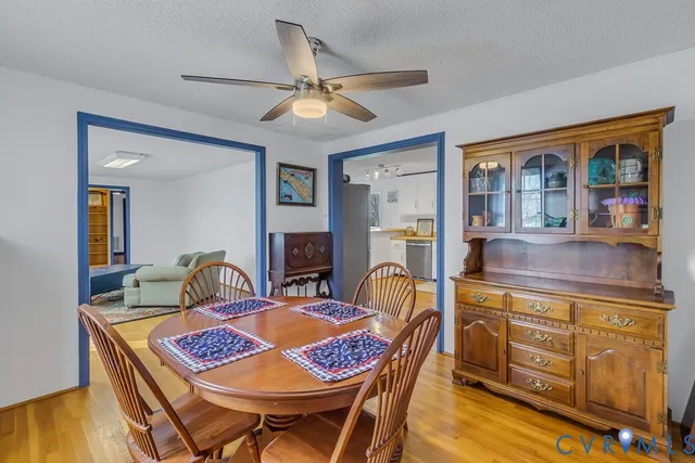 a view of a dining room with furniture a chandelier and wooden floor