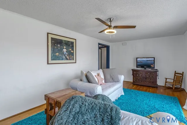 a living room with furniture and a wooden floor
