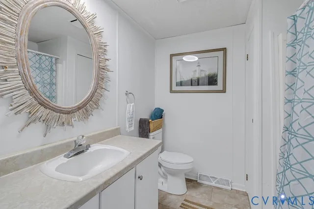 a bathroom with a toilet a sink and a mirror