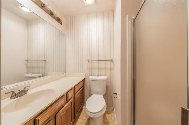 a bathroom with a sink a toilet a mirror and shower curtain