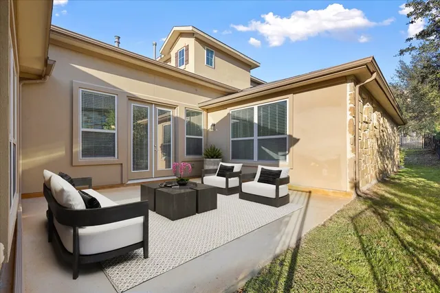 a living room with patio furniture and a large window
