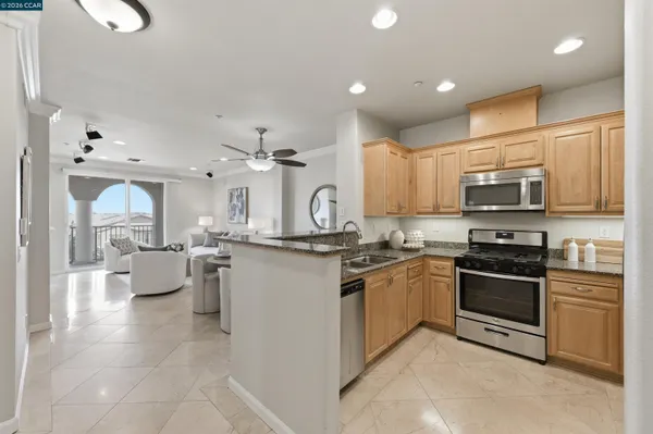a kitchen with stainless steel appliances granite countertop a stove top oven a sink dishwasher a dining table and chairs
