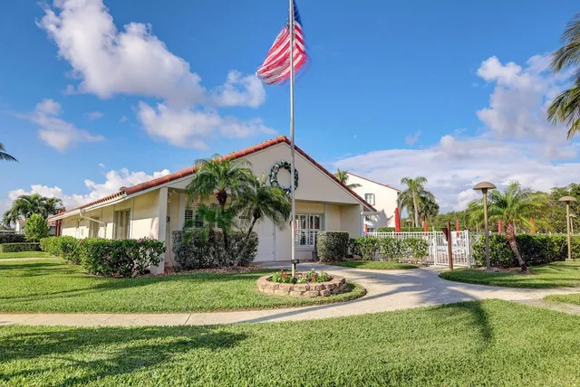 a front view of a house with a yard and potted plants