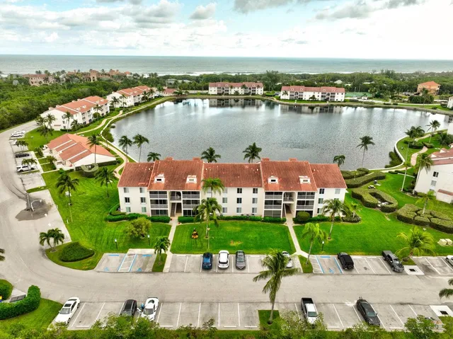 an aerial view of a house with a garden and lake view
